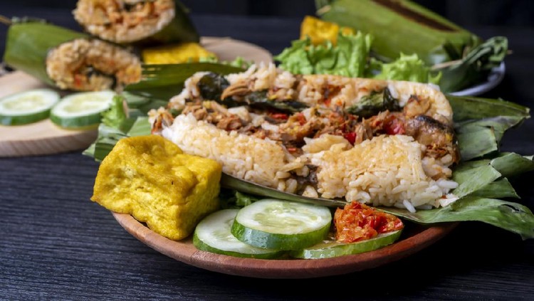 Nasi Bakar, Indonesian traditional food, filled with sliced chicken, decorated with cucumber, fried tofu, and chili sauce