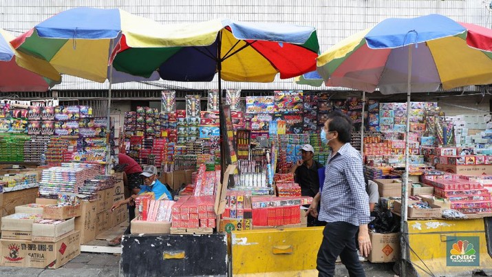 Pembeli memilih kembang api di Pasar Asemka, Jakarta, Kamis (16/12/2021). Sejumlah pedagang mengaku omzet penjualan kembang api tersebut menurun hingga 60 persen lebih karena adanya larangan berkerumun dan menggelar perayaan malam Tahun Baru 2022 sebagai pencegahan penyebaran virus COVID-19. Pantauan dilokasi, para pedagang menjajakan berbagai jenis kembang api di sepanjang kolong flyover Pasar Pagi hingga pinggir jalan. Salah satu pedagang, Idris (39) menyebut penjualan kembang api terus menurun pada tahun 2020, 2021 hingga 2022, biasanya 3 minggu sebelum tahun baru pesanan sudah mulai meningkat tapi sekarang belum ada karena ada PPKM dll