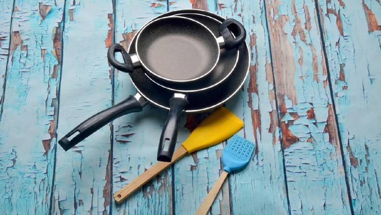 teflon frying pans on wooden table