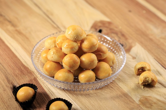 A Pile of Nastar or Ananas Taartjes or Pineapple Tart, Most Popular Various of Kue Kering Lebaran, Usually Served During Hari Raya. Wooden Background with Negative Space.
