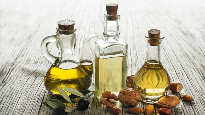 Olive, walnut and almond oil on wooden background