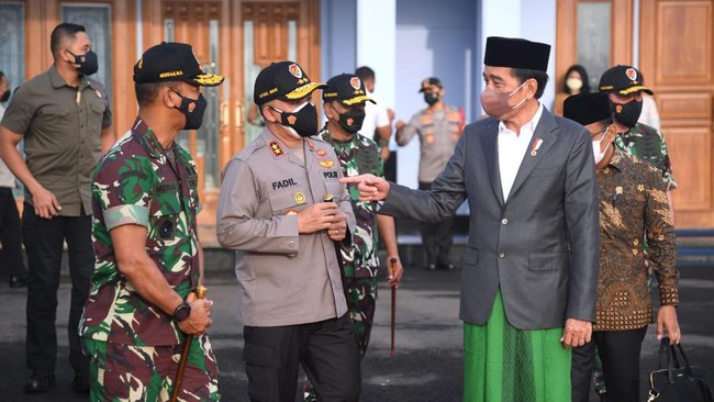 Berpeci, sarung berwarna hijau yang dipadankan dengan jas abu-abu dan kemeja putih jadi tampilan Presiden Jokowi saat hadiri Muktamar NU hari ini.