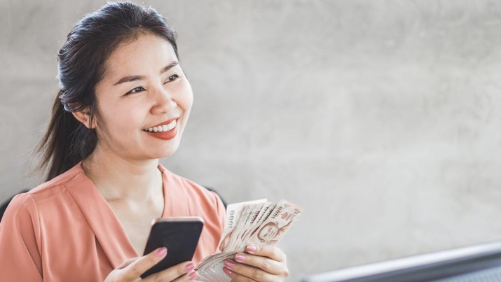 happy Asian woman hand holding smart phone and banknotes ,make money online concept
