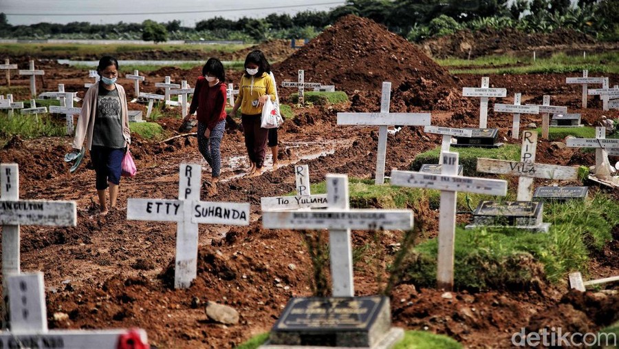Umat Nasrani melakukan ziarah makam keluarganya di kawasan Tempat Pemakaman Khusus COVID-19&comma; Rorotan&comma; Jakarta Utara&comma; Jumat &lpar;24&sol;12&rpar;&period;
