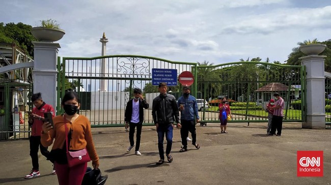 Sejumlah warga mendatangi kawasan Monas untuk berlibur meski ikon ibu kota itu masih ditutup untuk menghindari kerumanan saat libur Tahun Baru.
