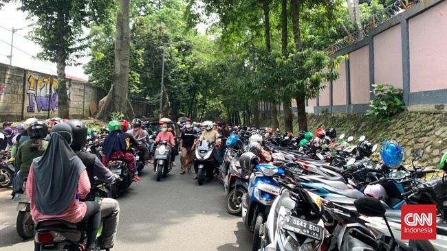 Pengunjung Ragunan yang terkena ganjil genap menitipkan kendaraan mereka di parkiran liar yang terletak di luar pagar kebun binatang.