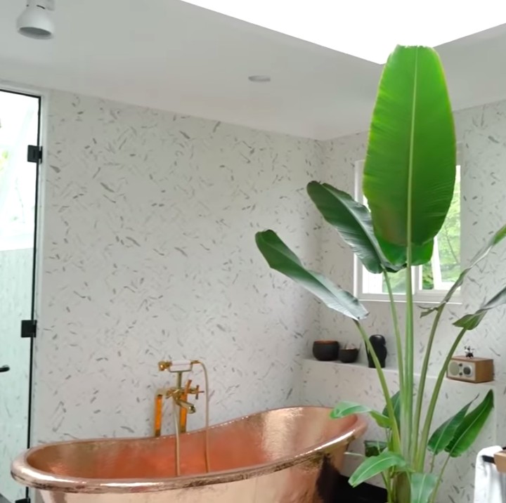 <p>Selain dilengkapi sofa dan meja, kamar mandi utama di rumah Sharena & Delon juga ber-AC, lho. Di sudut lain, ada bathtub bernuansa keemasan, satu cemin besar di dinding, serta shower yang terpisah partisi kaca sehingga area basah kamar mandi ini terkesan berada di luar ruangan. Wah, menarik, ya, Bunda! (Foto: YouTube Sharena Delon - Party of Four)</p>