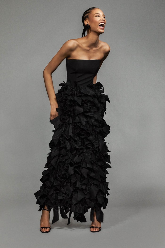 Tak hanya warna cerah, hitam turut ditampilkan. Yakni dalam kreasi gaun malam detail pita berbahan taffeta yang dramatis. Foto: Courtesy of Oscar de la Renta