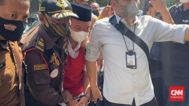 Herry Wirawan tampak mengenakan rompi tahanan berwarna merah dengan tangan diborgol menuju ruang sidang tuntutan kasus pemerkosaan 12 santriwati.