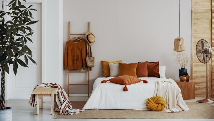 Copy space on empty white wall of natural bright bedroom interior