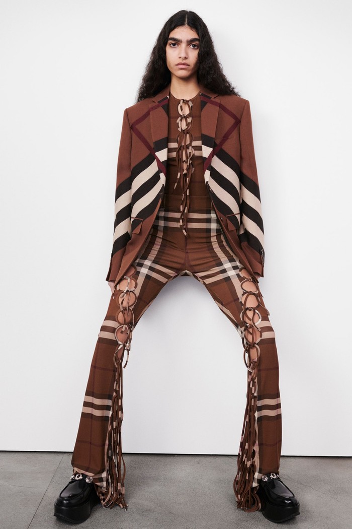 Motif check yang telah menjadi identitas Burberry dibuat menjadi seumpama corak grafis dalam rupa blazer dan celana detail cut-out. Foto: Chris Rhodes / Courtesy of Burberry