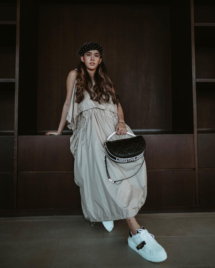 Cindy Karmoko menampilkan ide baru tampil sporty yakni lewat padanan dress aksen drawstring bersama sneakers, veil hat dan tas Dior Vibe. Foto: courtesy of Dior