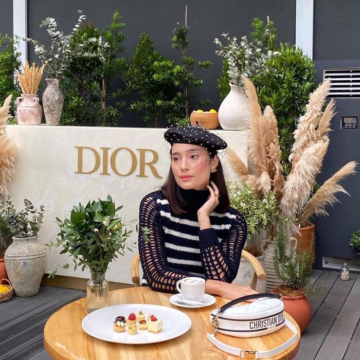 Tas Dior Vibe yang sporty dapat menjadi pelengkap sempurna untuk tampilan Parisian Chic seperti Tatjana Saphira yang mengenakan atasan garis dan beret hat. Foto: courtesy of Dior