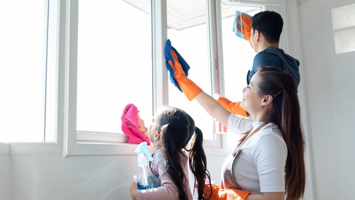 Asian Family helping cleaning House together. Dad, Mom and daughter are wiping dust on windowsill. Having fun on Holidays.