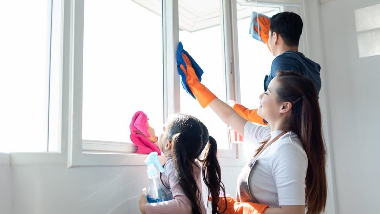 Asian Family helping cleaning House together. Dad, Mom and daughter are wiping dust on windowsill. Having fun on Holidays.