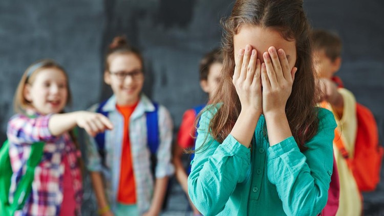bullying Schoolgirl crying on background of classmates teasing her