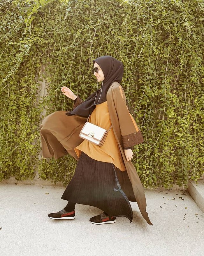Kombinasi warna hitam juga bisa memberikan kesan hangat pada outfitmu. Kenakan rok hitam dan outerwear berwarna coklat yang bisa menjadi padu padan yang chic. (@zaskiasungkar15)