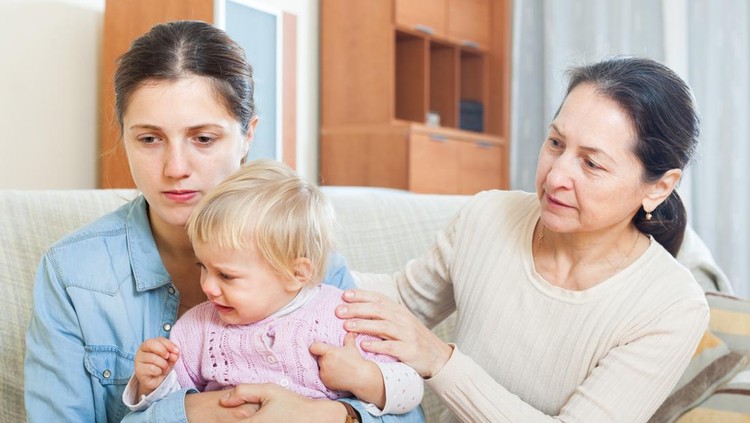 Conflict of intergenerational. Mature woman and young mother with baby after quarrel at home