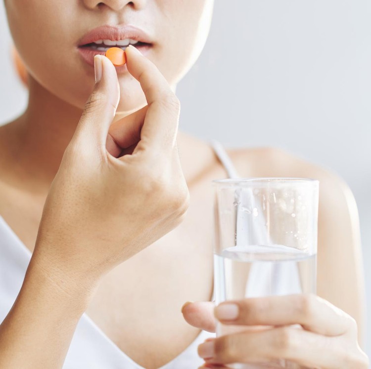 ilustrasi minum obat Woman taking tablet with glass of fresh water