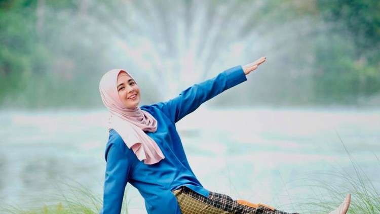 Risty Tagor dengan penampilan menggunakan celana panjang.