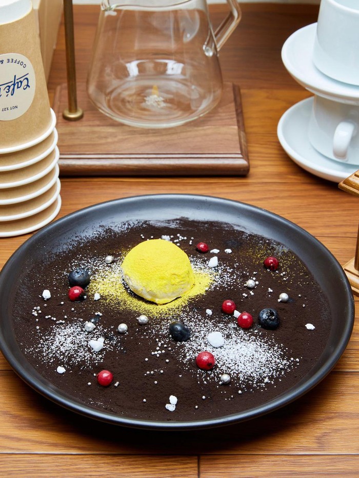 Dari penyajian menu, tersirat jelas bahwa menu ini terinspirasi dari Moon Taeil. Sajian dessert dengan tampilan sinar rembulan di antara benda luar angkasa ini di beri nama 'Moon Cream Brulee' / Foto: twitter.com/NCT_OFFICIAL_JP