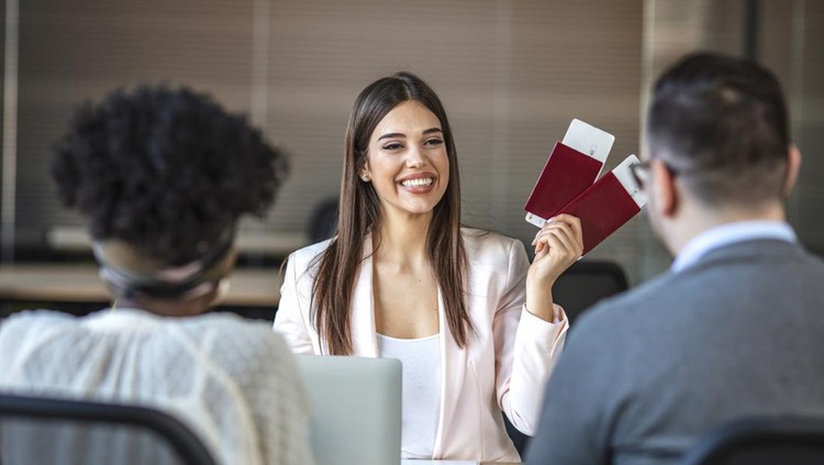 The travel agent keeps tickets for the plane in the travel agency.  She offers them to clients. Couple at the travel agency office prepairing for a summer vacation. Concept for travel agent.