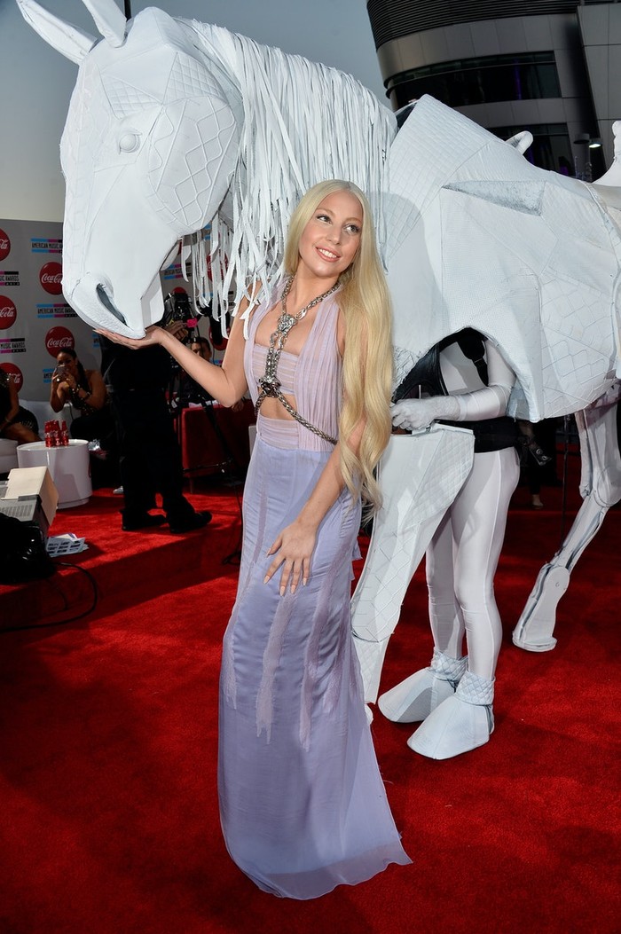 Bikin mata terpana, Lady Gaga tiba di karpet merah American Music Awards mengenakan gaun Atelier Versace dan 'kuda' yang dibuat dari tas Chanel seperti yang diceritakannya kepada British Vogue./Foto: Getty Images