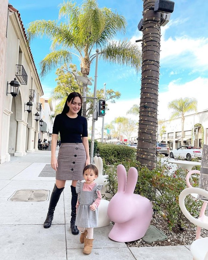 Kali ini Shandy memilih rok span motif kotak yang dipadukan dengan kaus hitam dan boots hitam. Bersama baby Claire yang juga kompak mengenakan outfit bermotif sama. (@shandyaulia)