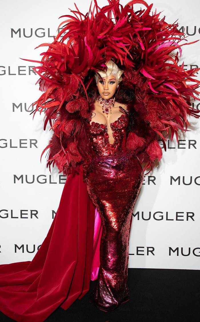Cardi B merupakan salah satu selebriti yang menggemari kreasi Thierry Mugler. Salah satu gaun yang pernah dipakaianya yaitu gaun couture merah mencolok dengan aksen bulu dramatis yang sangat merepresentasikan ciri khas Mugler. Foto: pinterest.com/People