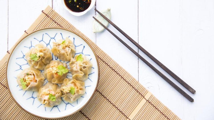 Traditional chinese steamed dumplings Dim Sums with sauce and chopsticks on light surface with copy space. Flat lay composition Asian food background.