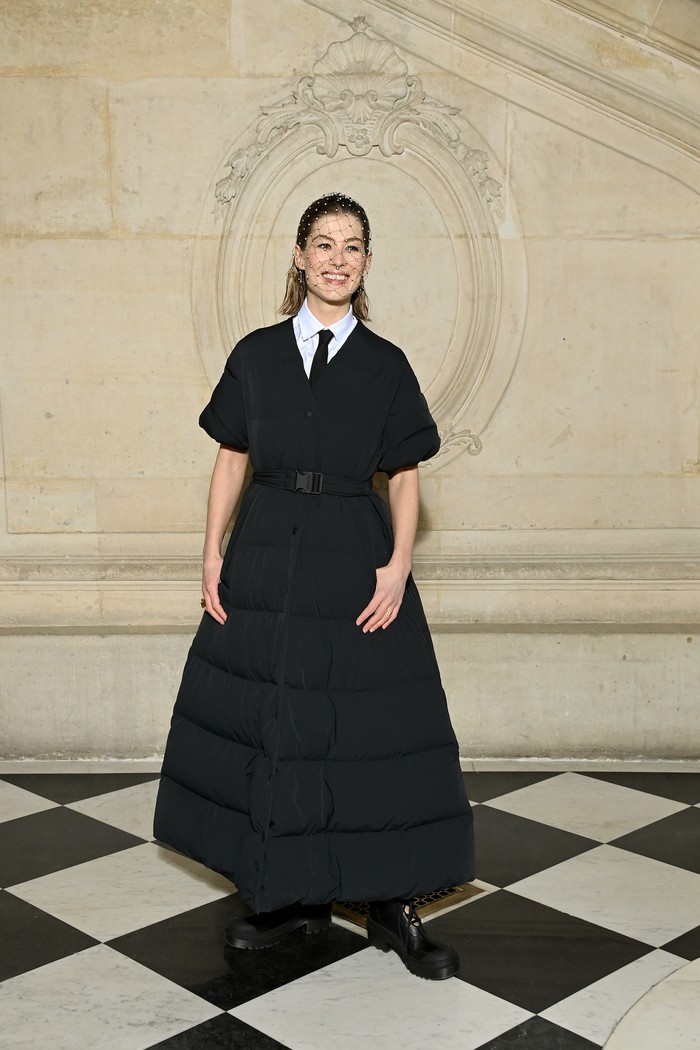 Puffer coat menjadi pilihan Rosamund Pike untuk memberi twist pada tampilan klasik dan formalnya. Foto: Getty Images For Dior/Pascal Le Segretain