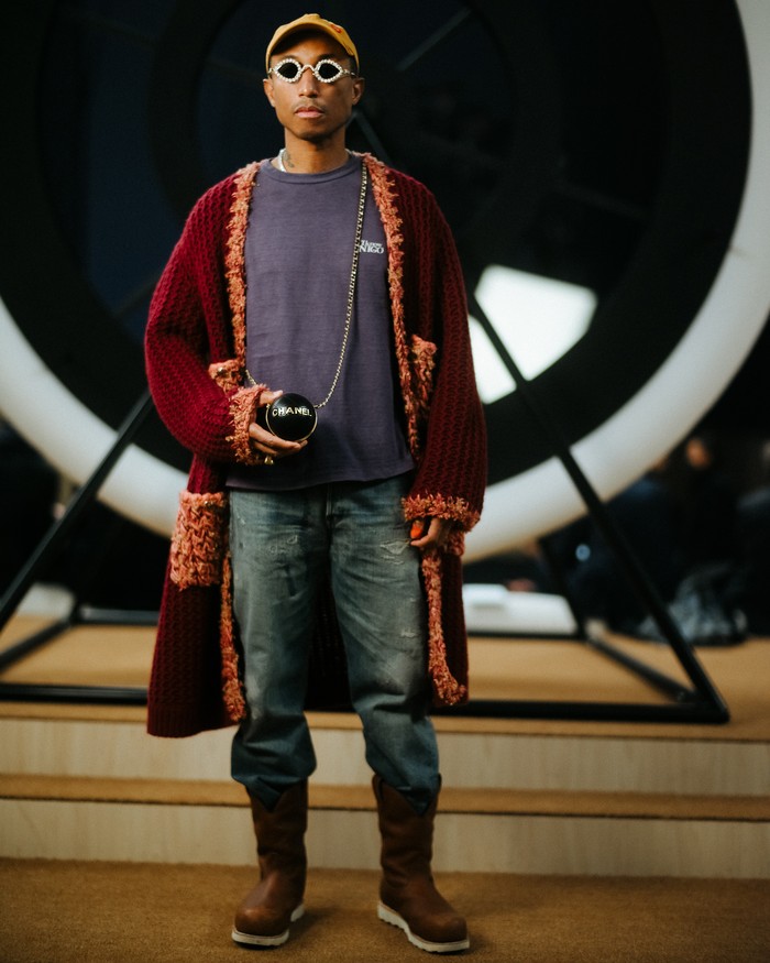 Pharell kembali membuktikan bahwa pria pun dapat memakai koleksi busana Chanel seperti sebuah coat burgundy yang terlihat stylish bersama kaus dan jeans. Foto: Courtesy of Chanel