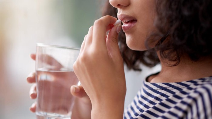 Cropped shot of an unrecognizable teenage girl drinking medication