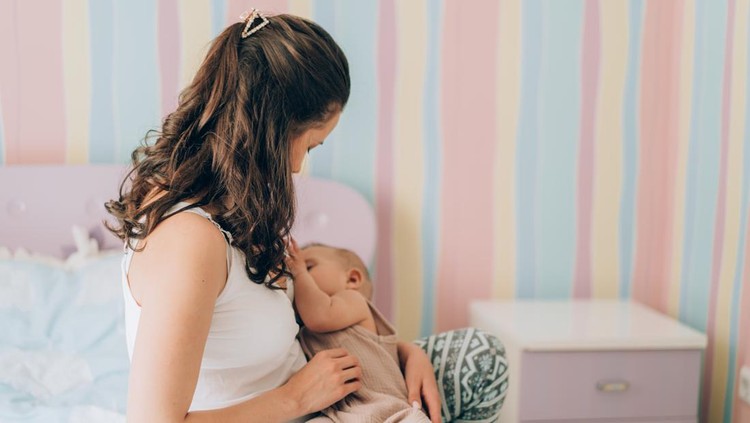 Young mother is breastfeeding her baby. In Vitro Fertilization (IVF). Family of asians.