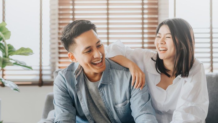 Happy Asian couple having fun and laughing together in living room at home Tingkat Kecocokan Pasangan Berdasarkan Urutan Lahir