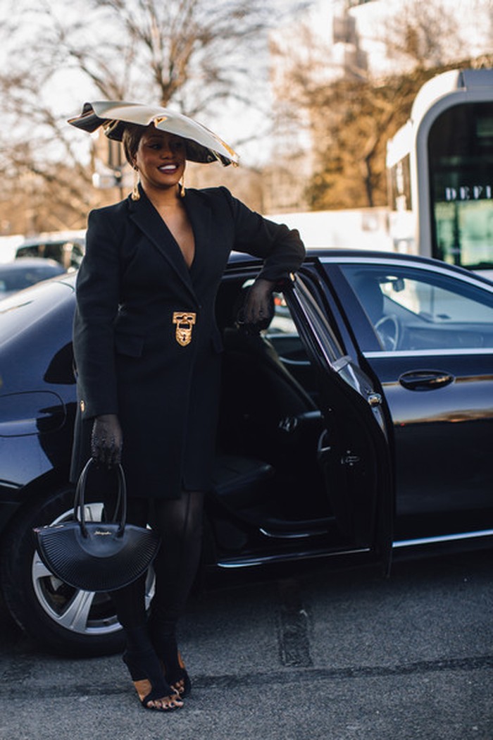Bersamaan dengan ikat pinggang dan tas khas Schiaparelli, aktris Laverne Cox menampilkan elegansi dari topi emas eklektik. Foto: Livingly/IMAXtree