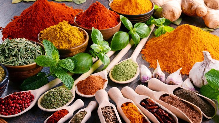 Variety of spices and herbs on kitchen table.