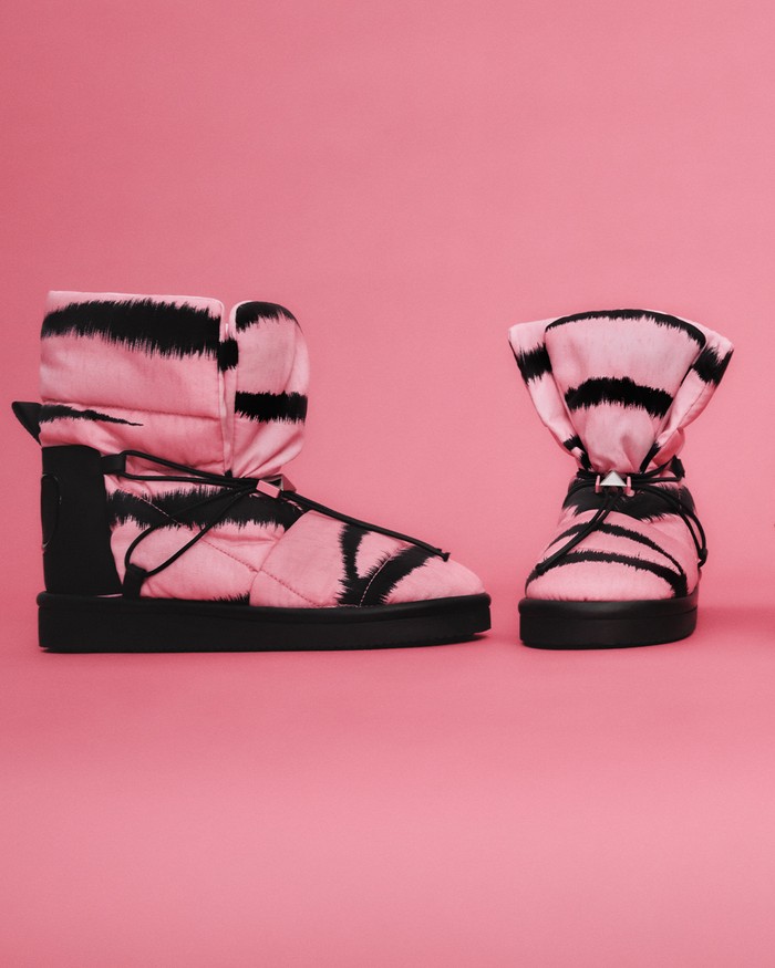 Sepatu boots dalam warna neon pink dan corak loreng menjadi pelengkap sempurna pada tampilan serba feminin pada koleksi ini. Foto: courtesy of Valentino