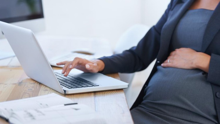 Cropped image of a pregnant businesswoman working on her laptop in the office