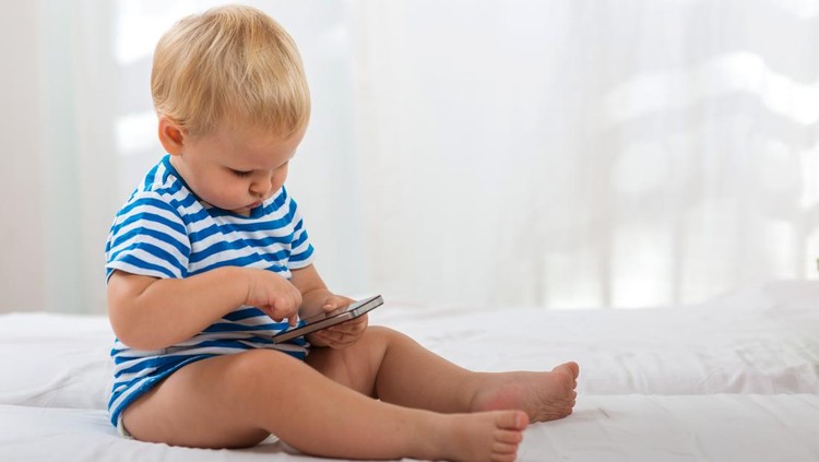 Casual baby watching a mobile phone