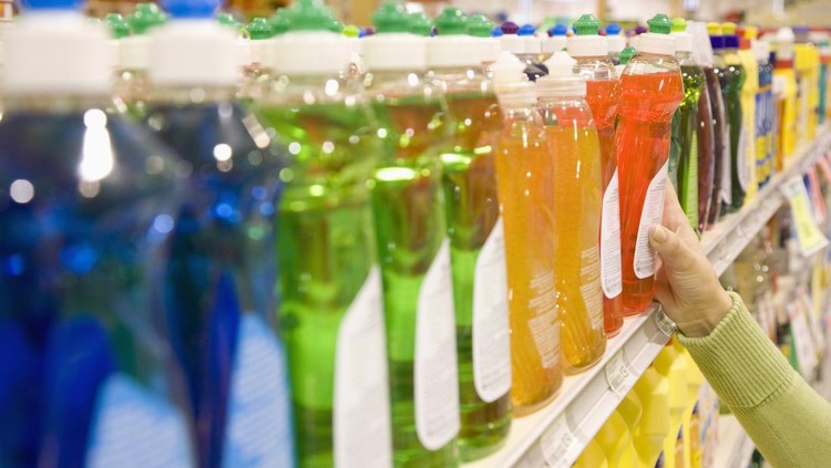 Woman selecting dishwashing liquid product in supermarket
