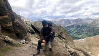 <p>Berlatar pemandangan menakjubkan, ia berpose keren di atas batu. Meski kini sudah tak muda lagi, penampilan Atiek tetap menawan ya. (Foto: Instagram @atiekcb.official)</p>