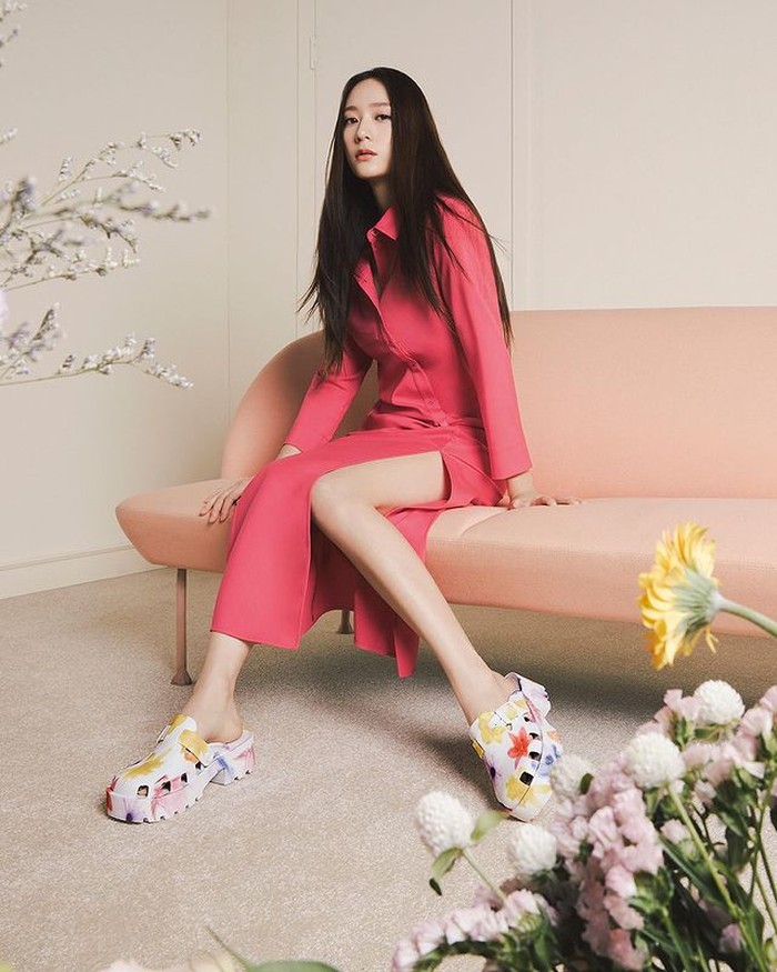 Senada dengan tas koleksi terbaru Charles & Keith, ‘Chunky Alex Platform Sandals’ memiliki desain yang berani, didominasi warna putih dengan corak bunga warna-warni. Cocok dengan dress pink fanta yang dikenakan Krystal. / foto: instagram.com/wkorea