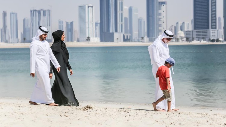 Arab family walking on the autumn beach