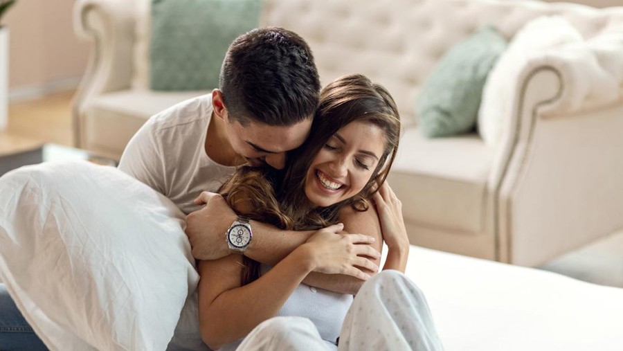 ilustrasi pasangan Happy affectionate couple enjoying in their love while embracing in bedroom in the morning.