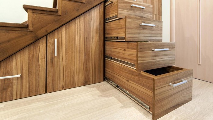 Modern architecture interior with  luxury hallway with glossy wooden stairs in modern storey house. Custom built pullout cabinets on glides in slots under stairs
