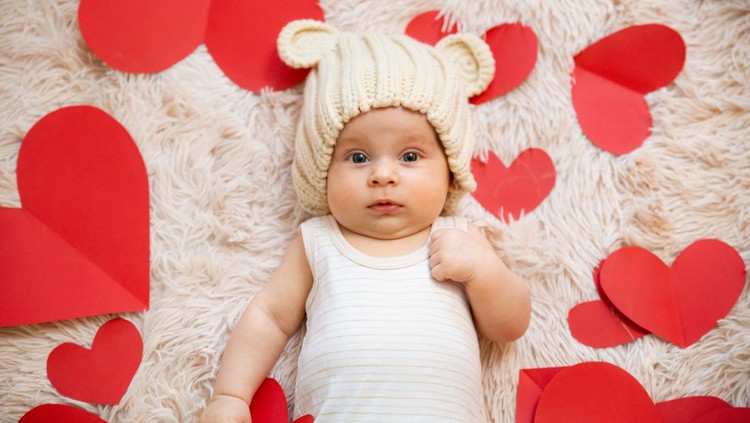 3 month old baby with teddy bear hat and t-shirt photographed with red hearts