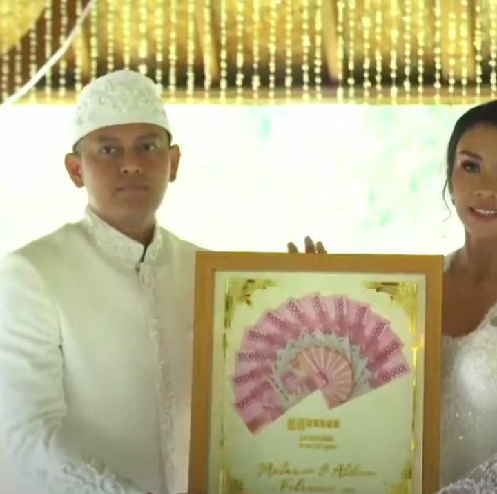 <p>Pasangan ini tak lupa berfoto dengan mahar pernikahan, yakni berupa uang tunai Rp 12.022.022 dan logam mulai 12,2 gram. (Foto: YouTube Fit with MeL - by Melanie Putria)</p>