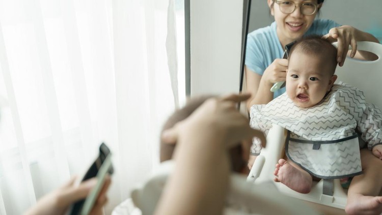 Close up portrait of toddler child getting his first haircut