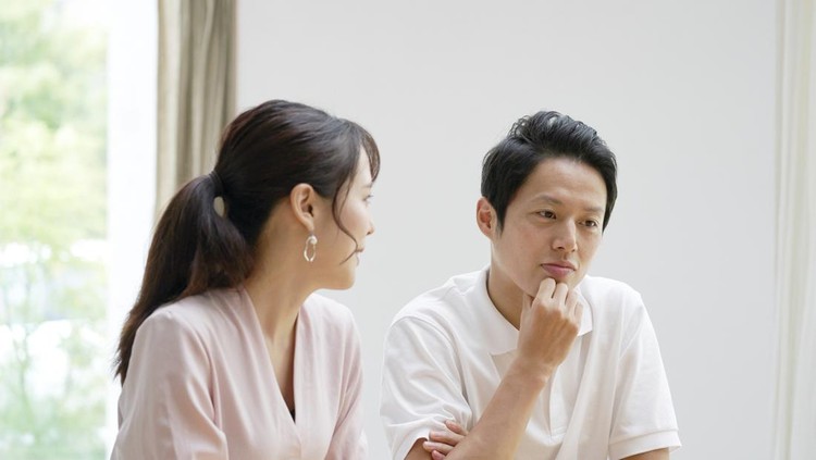 Asian couple talking at home